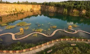 Malowniczy zalew w kamieniołomie Gródek Jaworzno, z drewnianymi kładkami i altanką. Warto sprawdzić park Gródek Jaworzno cena wstępu.