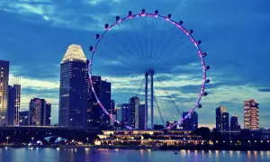 Wieczorny widok na Singapur z diabelskim młynem i drapaczami chmur. Marzenie o podróży, wiza do Singapuru czeka!