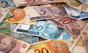 Stosy banknotów w różnych nominałach, w tym 100, 10 i 5 reali. To waluta w Brazylii.