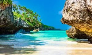 Rajska plaża na Zanzibarze, z turkusową wodą i skalistymi klifami porośniętymi zielenią. Idealne miejsce, by zobaczyć, co Zanzibar ma do zaoferowania.