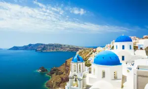 Santorini: białe domy, niebieskie kopuły kościołów i turkusowe morze. Idealne miejsce na tanie wakacje w Grecji.