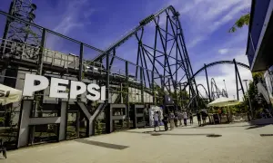 Energylandia opinie: ogromna kolejka górska Pepsi z ludźmi w tle.