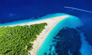 Zloty Róg, Chorwacja. Plaże i turkusowe morze Adriatyku, idealne na wakacje. Łódź motorowa przecina błękitne wody.