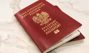 Dwa polskie paszporty, symbole wolności podróżowania i jedne z najsilniejszych paszportów na świecie, leżą na marmurowym blacie.