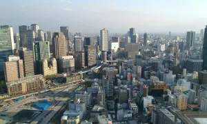 Widok na rozległe miasto z drapaczami chmur. Zastanawiasz się, ile się leci do Japonii, patrząc na ten krajobraz?