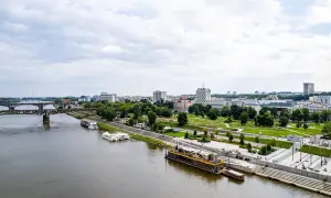 Widok na Wisłę i warszawskie Powiśle z nowoczesnymi bulwarami, mostem i zabudową miejską w tle.