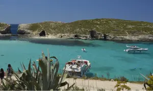 Malta wycieczki: turkusowa woda, łodzie i skaliste wybrzeże. Idealne miejsce na wakacje.
