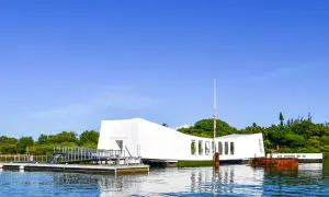 Pomnik USS Arizona w Pearl Harbor, biała konstrukcja nad wodą, upamiętnia tragiczne wydarzenia.