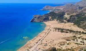Widok na zatokę z piaszczystą plażą, leżakami i wodnym parkiem rozrywki. To jedno z rodos najpiękniejsze miejsca.