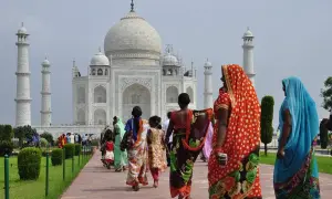 Kobiety w barwnych sari spacerują ścieżką ku Taj Mahal. Marzenie o podróży do Indii i uzyskaniu wizy do Indii staje się rzeczywistością.