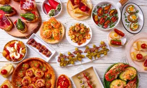 Bogactwo hiszpańskiego jedzenia: tapas z krewetkami, małżami, owocami morza, wędlinami i warzywami.