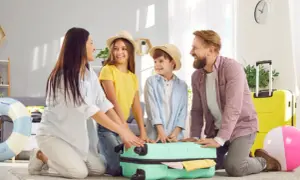 Rodzina pakuje walizkę, zastanawiając się, co zabrać na wakacje. Wszyscy uśmiechnięci, gotowi na przygodę.