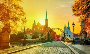 Zachód słońca nad Ostrowem Tumskim we Wrocławiu, idealny na city break z Wrocławia. Most Tumski i katedra w złotym blasku.
