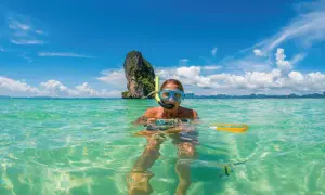 Kobieta w masce do snorkelingu pływa w turkusowej wodzie. Czy Tajlandia jest bezpieczna? Tak, to raj dla turystów!