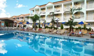 Basen i leżaki przy hotelu Admiral Tsilivi. Goście odpoczywają, a budynek hotelowy odbija się w krystalicznie czystej wodzie.