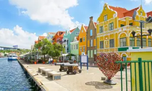 Kolorowe kamienice nad wodą, armaty i serce z kłódek – idealne miejsce na curacao wakacje.