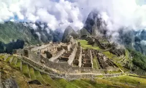Niesamowita wycieczka do Machu Picchu. Ruiny Inków w chmurach, otoczone zielonymi tarasami i stromymi górami.