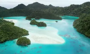 Rajskie krajobrazy Raja Ampat: turkusowa woda, białe plaże i bujna zieleń tropikalnych wysp.