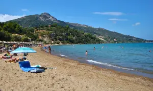 Idealna zakynthos pogoda czerwiec: słońce, plaża i kąpiel w turkusowym morzu. W tle zielone wzgórza.