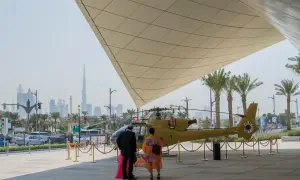 Luksusowe dubaj wczasy: ludzie podziwiają helikopter na tle drapaczy chmur.