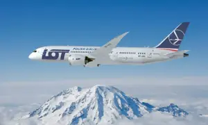 Samolot LOT Polish Airlines leci nad ośnieżonymi górami.
