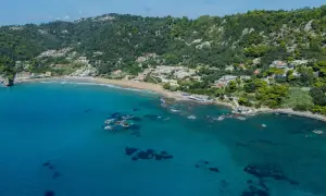 Widok na zatokę z piaszczystą plażą i zielonymi wzgórzami. To malownicza mysia wyspa Korfu, idealna na wakacje.