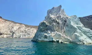 Skaliste wybrzeże Santorini, z turkusową wodą i białymi klifami, zaprasza do odkrywania ukrytych plaż.