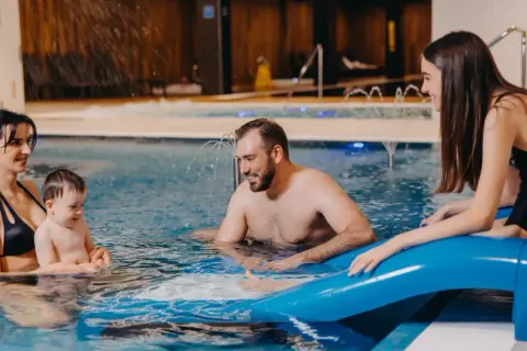 Rodzina cieszy się wodnym szaleństwem w basenie. Idealny hotel dla dzieci w górach, gdzie każdy znajdzie coś dla siebie.