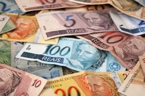 Stosy banknotów w różnych nominałach, w tym 100, 10 i 5 reali. To waluta w Brazylii.