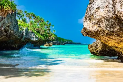 Rajska plaża na Zanzibarze, z turkusową wodą i skalistymi klifami porośniętymi zielenią. Idealne miejsce, by zobaczyć, co Zanzibar ma do zaoferowania.