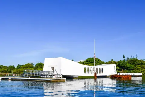 Pomnik USS Arizona w Pearl Harbor, biała konstrukcja nad wodą, upamiętnia tragiczne wydarzenia.