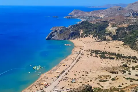 Widok na zatokę z piaszczystą plażą, leżakami i wodnym parkiem rozrywki. To jedno z rodos najpiękniejsze miejsca.