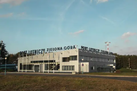 Port Lotniczy Zielona Góra Babimost. Budynek terminala lotniska z napisem na dachu.
