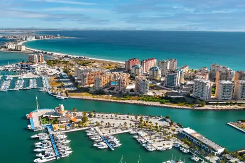 Widok na la manga hiszpania z licznymi jachtami w marinach i apartamentowcami nad turkusowym morzem.