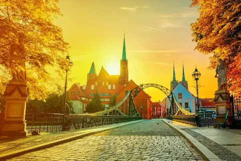 Zachód słońca nad Ostrowem Tumskim we Wrocławiu, idealny na city break z Wrocławia. Most Tumski i katedra w złotym blasku.