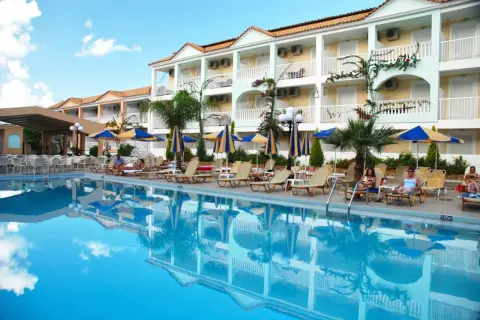 Basen i leżaki przy hotelu Admiral Tsilivi. Goście odpoczywają, a budynek hotelowy odbija się w krystalicznie czystej wodzie.