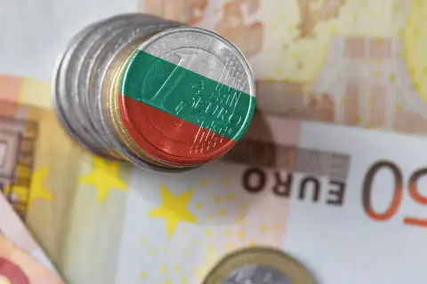Monety z flagą Bułgarii leżą na banknotach euro. Waluta Bułgarii, lew, obok euro.