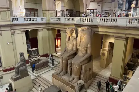Wielkie posągi faraonów w nowym muzeum w Kairze. Zwiedzający podziwiają starożytne artefakty.