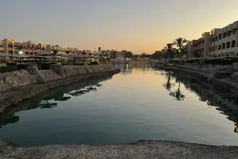 Zachód słońca nad kanałem w Hurghadzie. Widok na hotele i palmy, idealne miejsce na relaks. Atrakcje w: Hurghada.