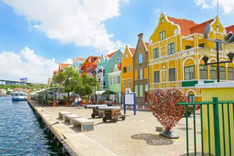 Kolorowe kamienice nad wodą, armaty i serce z kłódek – idealne miejsce na curacao wakacje.