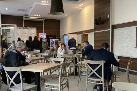 Ludzie jedzą w barze mlecznym, szukając dobrego jedzenia w Warszawie.