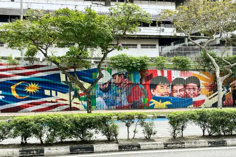 Kolorowy mural z flagą Malezji i uśmiechniętymi dziećmi. Wiza do Malezji może być potrzebna, ale sztuka jest zawsze mile widziana.