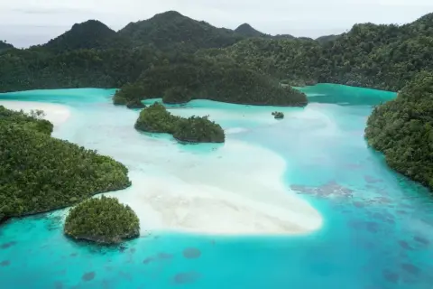 Rajskie krajobrazy Raja Ampat: turkusowa woda, białe plaże i bujna zieleń tropikalnych wysp.