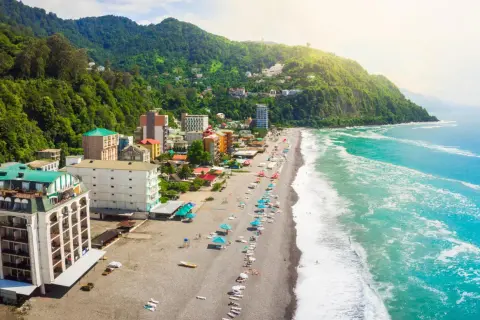 Widok z lotu ptaka na wybrzeże Gruzji. Plaże, hotele i zielone wzgórza nad turkusowym morzem.