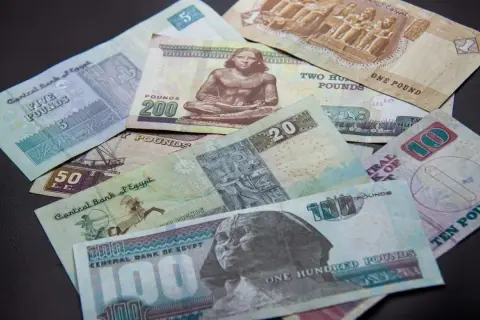Różne banknoty funta egipskiego, od 1 do 200, leżą na czarnym tle. Planujesz podróż i zastanawiasz się, jakie dolary do Egiptu? Lepiej zabrać funty!