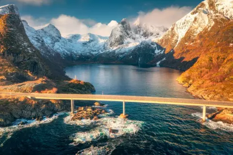 Mosty nad wodą, otoczone ośnieżonymi górami, idealne na fiordy norweskie wycieczka.