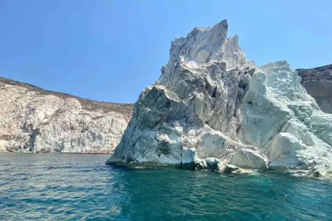 Skaliste wybrzeże Santorini, z turkusową wodą i białymi klifami, zaprasza do odkrywania ukrytych plaż.