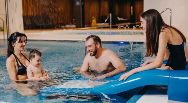 Rodzina cieszy się wodnym szaleństwem w basenie. Idealny hotel dla dzieci w górach, gdzie każdy znajdzie coś dla siebie.