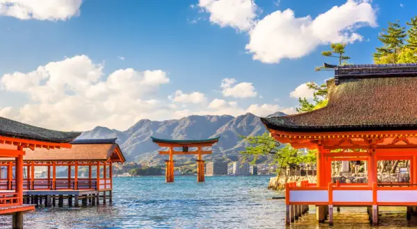 Japonia wycieczka Itaka: widok na słynną bramę torii w morzu i tradycyjne budynki świątynne na wodzie.