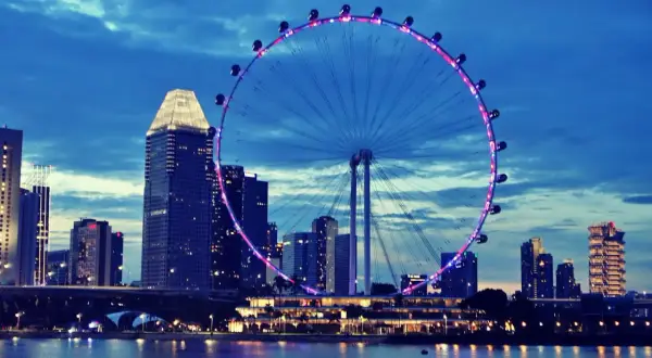 Wieczorny widok na Singapur z diabelskim młynem i drapaczami chmur. Marzenie o podróży, wiza do Singapuru czeka!